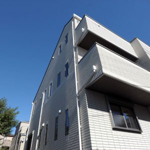 重量感のある総タイル貼りの高級かつスタイリッシュな外観。<br>法規制ギリギリまで広げた３階北側斜線部分は収納スペースに。
