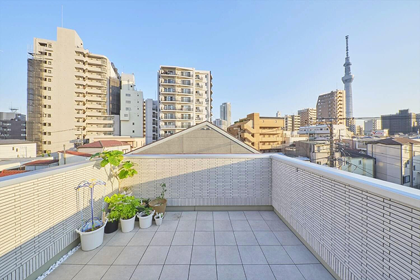 夕日が差し込み、スカイツリーが見える屋上